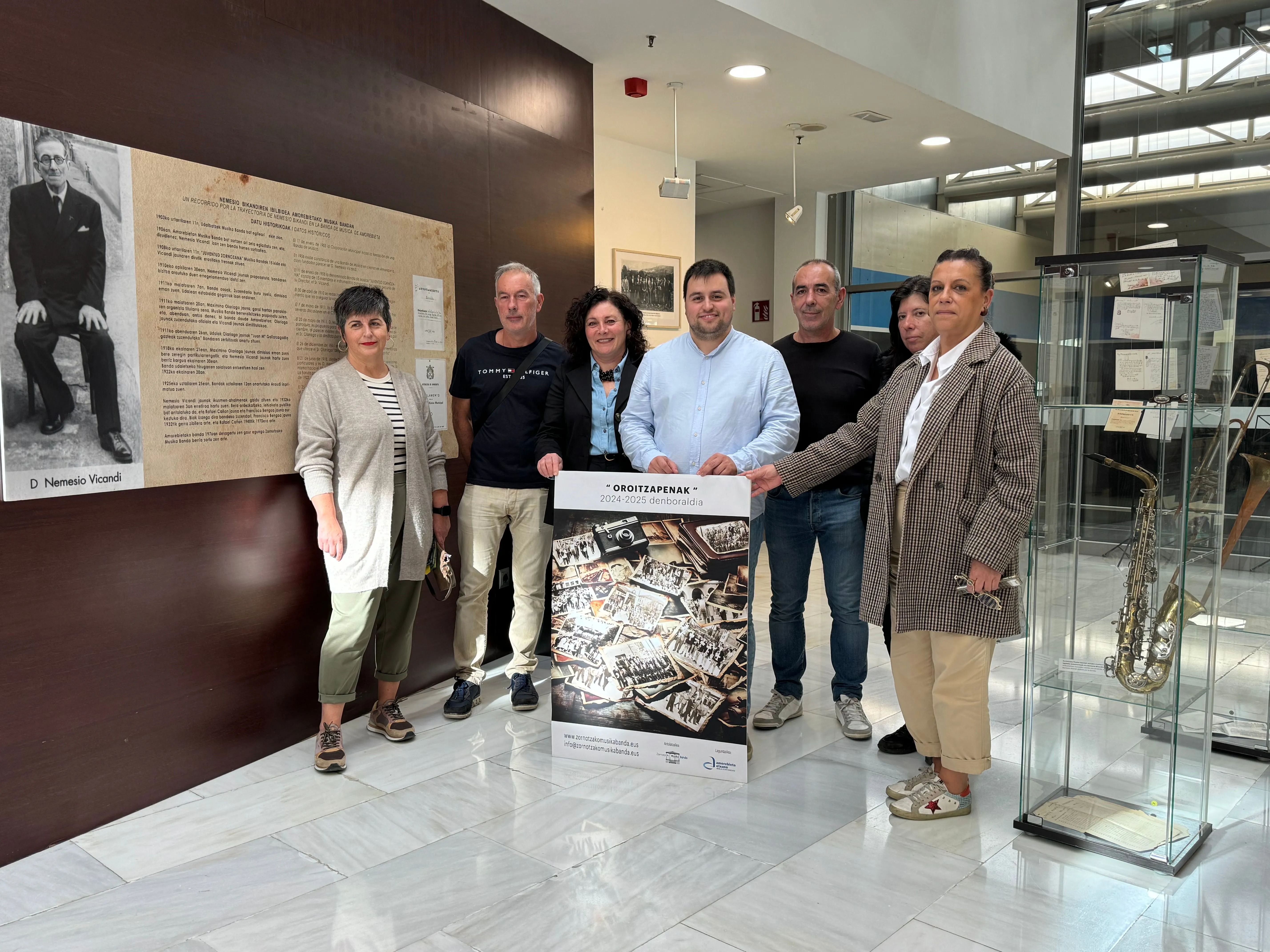 Foto del director de la banda, el alcalde de la localidad y la familia del homenajeado.